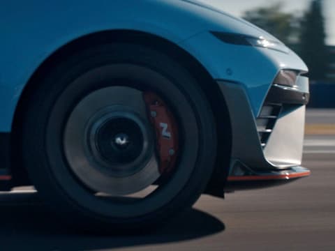 Крупен план на колелото на IONIQ 6 N — акцент върху спирачния апарат и дизайна на джантата в движение.