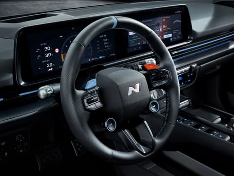 Изглед към волана на IONIQ 6 N, отличаващ се с дигитални дисплеи и модерни бутони за управление.