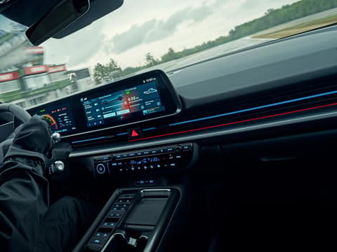 Детайл от кокпита на IONIQ 6 N по време на шофиране, с фокус върху интерактивния дигитален панел.