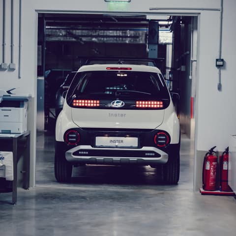 Hyundai INSTER Cross, движещ се по градска улица.