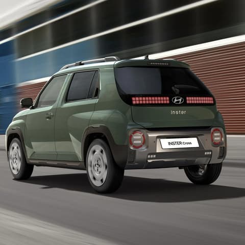 Hyundai INSTER Cross, движещ се по градска улица.