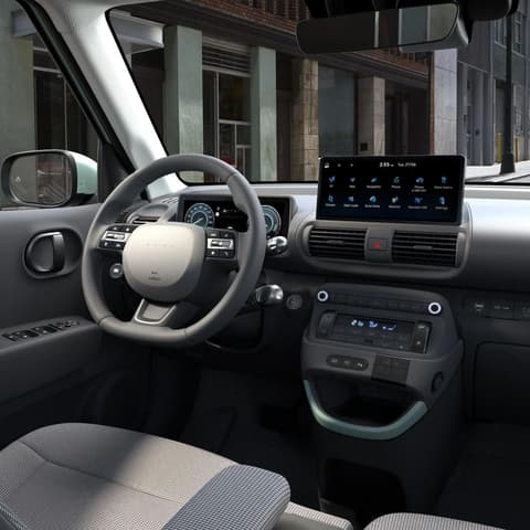 Мъж, облегнат на сгънатата предна седалка на новия Hyundai INSTER Cross.