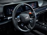 Изглед към волана на IONIQ 6 N, отличаващ се с дигитални дисплеи и модерни бутони за управление.