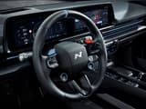 Детайлен изглед към волана на Hyundai IONIQ 6 N с бутони и дигитален инструментален клъстер на заден план.