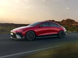 Новият Hyundai IONIQ 6 N Line в червено се движи по магистрала с хълмове на заден план.