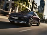 HYUNDAI IONIQ 6 в движение по градска улица, заснет от нисък заден ъгъл, подчертаващ скоростта, динамиката и модерния дизайн.