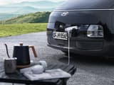 Преден порт за зареждане на Hyundai STARIA Electric, захранващ външно устройство чрез функцията Vehicle-to-Load (V2L).