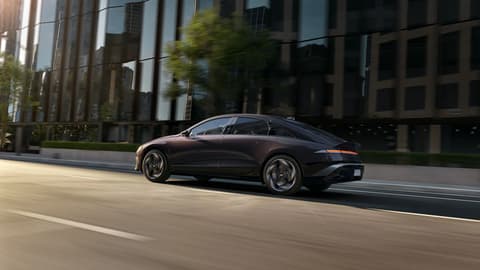 Hyundai IONIQ 6 електрически седан, заснет отстрани в движение по градска улица.