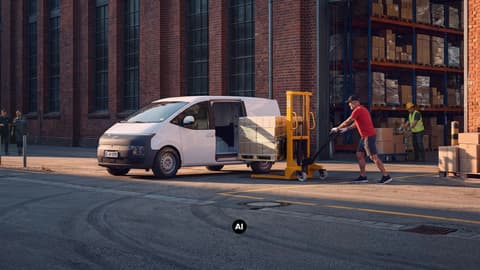 Товарене на палетизирани кашони в Hyundai STARIA Cargo пред склад.