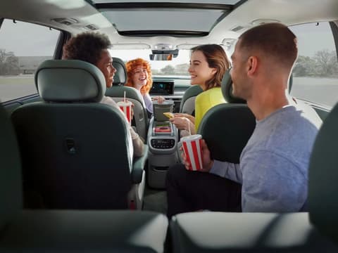 Четирима души във вътрешността на Hyundai IONIQ 9, споделящи закуски и напитки.