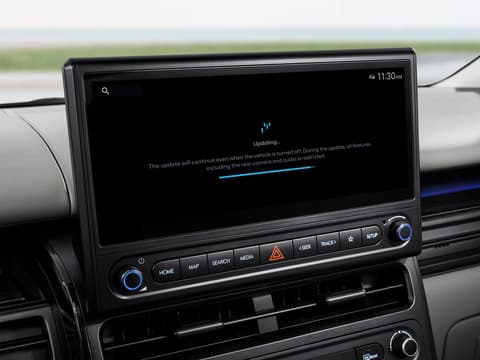Близък план на екрана на таблото на Hyundai STARIA Electric, показващ статус и лента за напредък на OTA актуализация.