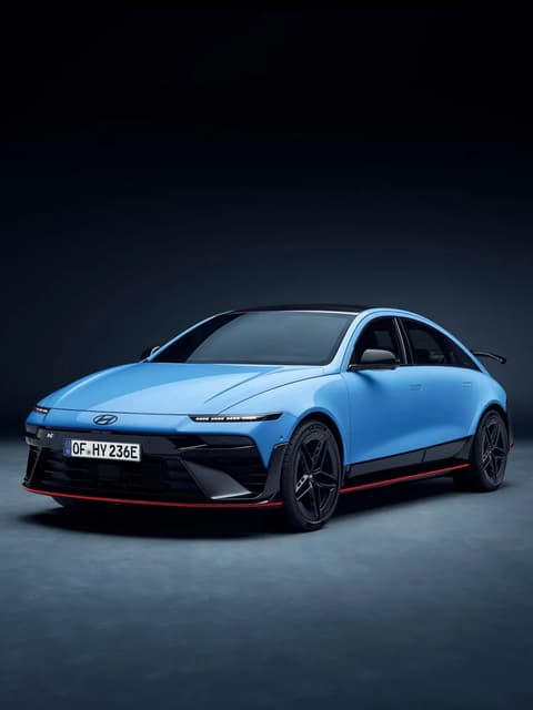 Front quarter view of Hyundai IONIQ 6N in studio setting, showcasing bold grille and sporty stance.