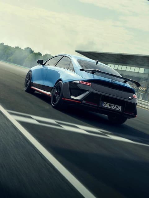 IONIQ 6 N в динамика на пистата, демонстрирайки елегантен дизайн и аеродинамични елементи в движение.