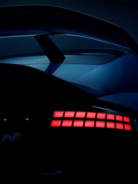 Изглед отгоре на Hyundai IONIQ 6N върху извита рампа, акцентиращ върху аеродинамичния покрив и задното крило.