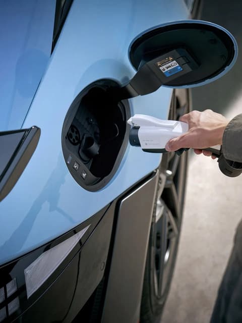 Близък план на човек, който включва заряден кабел към зарядното гнездо на Hyundai IONIQ 6 N.