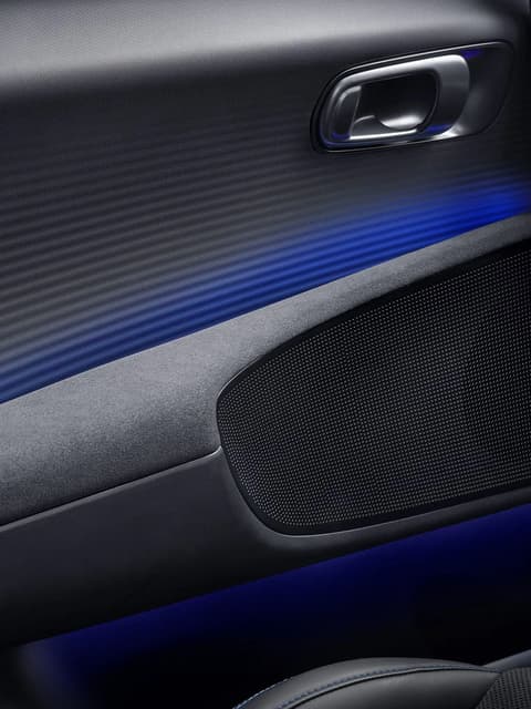 Велурен подлакътник на вратата и модерни бутони с амбиентно осветление в интериора на Hyundai IONIQ 6 N.