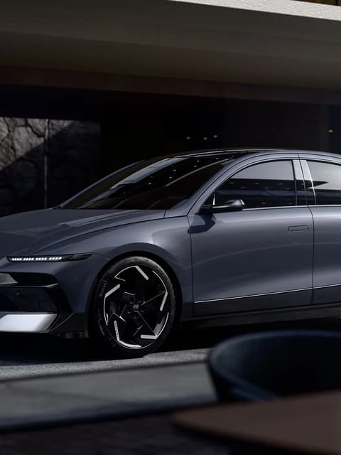 Hyundai IONIQ 6 електрически седан, паркиран пред модерна сграда.