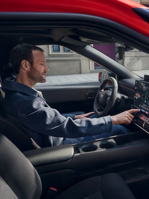  A man in the driver's seat interacting with the touchscreen display of Hyundai IONIQ 3