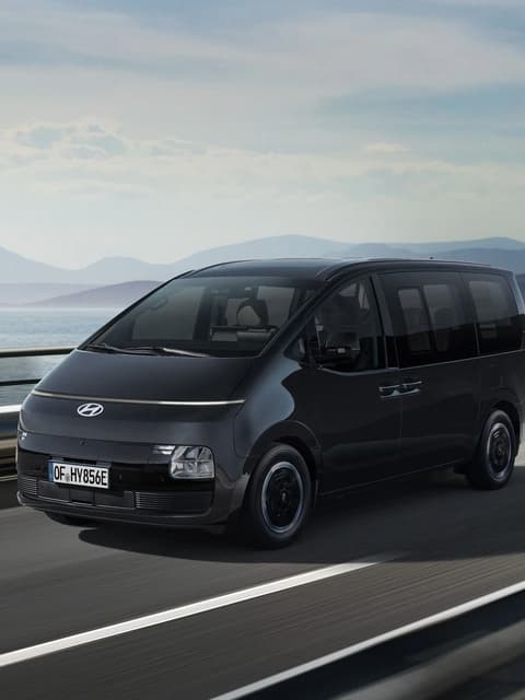 Страничен изглед на Hyundai STARIA Electric в движение по крайбрежен път