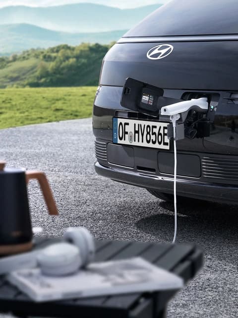Предна вратичка за Зареждане на Hyundai STARIA Electric, подаваща Мощност към външно устройство чрез функционалността Vehicle-to-Load (V2L).