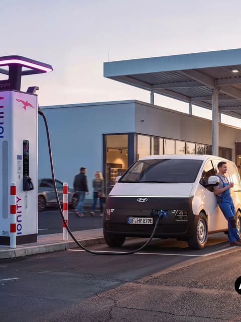 Работник до Hyundai STARIA Cargo, който се зарежда на станция IONITY.
