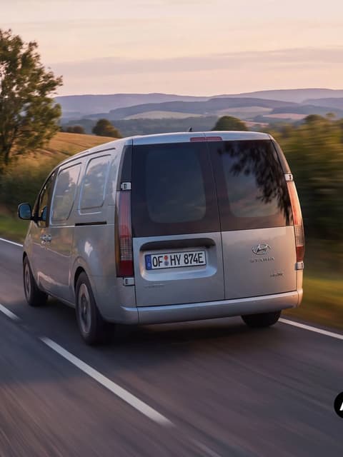 Hyundai STARIA Cargo, заснет отзад, по път в селска местност.
