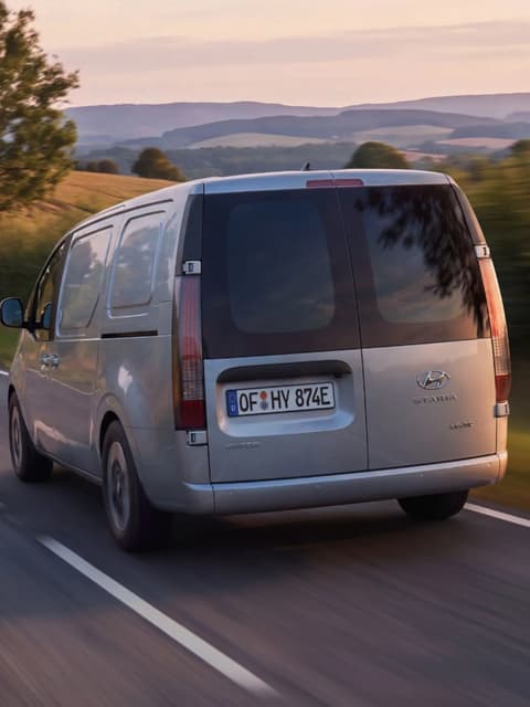 Hyundai STARIA Cargo, заснет отзад, по път в селска местност.