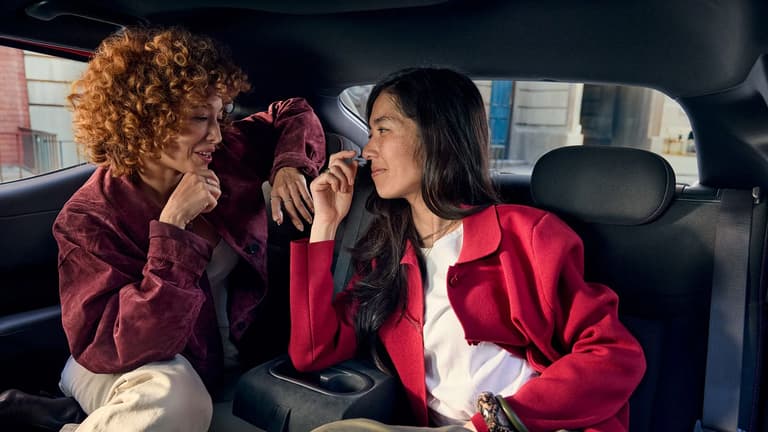 Two people chatting in the back seat of a Hyundai IONIQ 3.