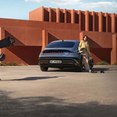Жена се обляга на Hyundai IONIQ 6 електрически седан.