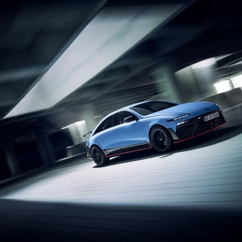 Hyundai IONIQ 6N при движение през модерна сграда, акцентира върху маневреността и динамиката.