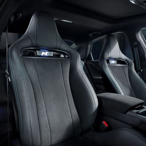 Интериор с осезаемо спортни предни седалки в Hyundai IONIQ 6 N, подчертаващи комфорт и стил със забележителни шевове.