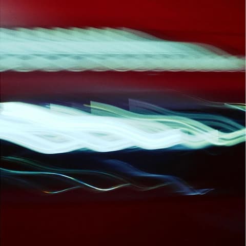 Светлинни следи от Hyundai IONIQ 3 в бяло и синьо на фона на червен декор.