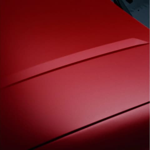 Червен Hyundai IONIQ 3 – детайл на формованите купе линии върху гладката външна повърхност.