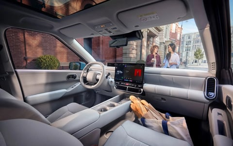Интериор на Hyundai IONIQ 3 с торба багети на пода пред предната пътническа седалка.