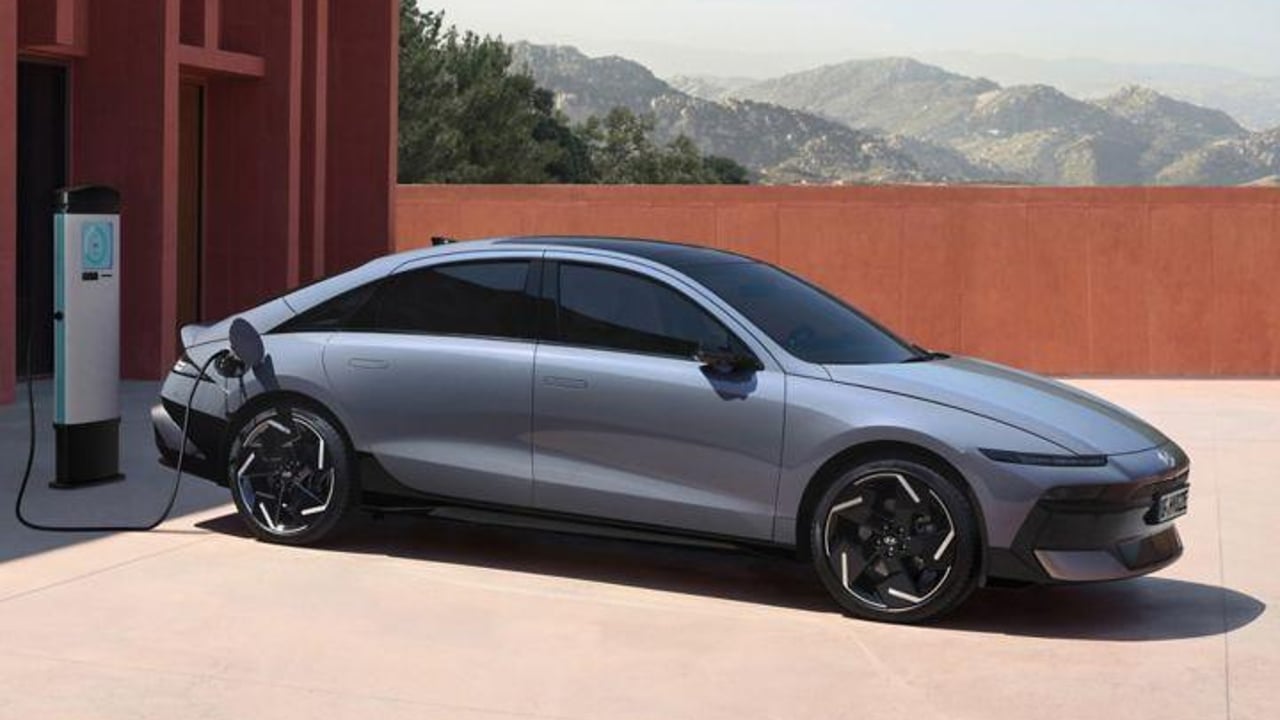 The Hyundai IONIQ 6 electric sedan plugged into charge with mountains in the background.