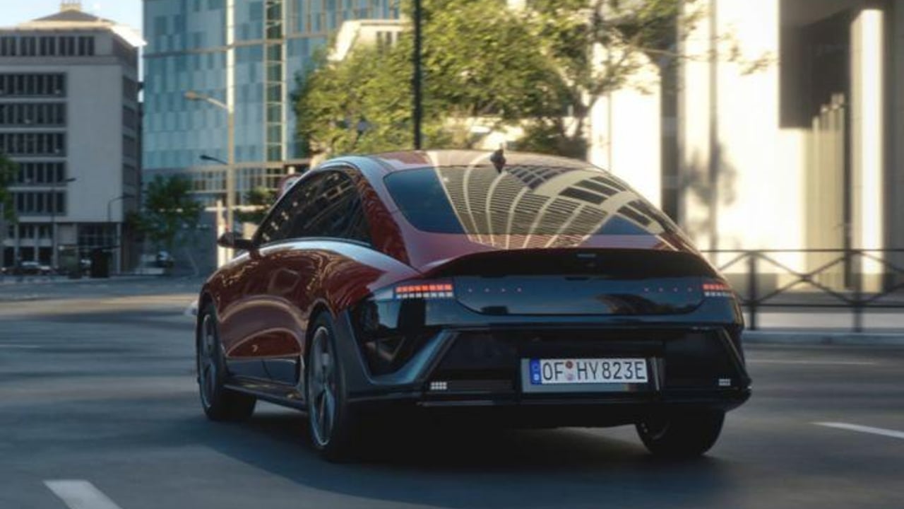 A red Hyundai IONIQ 6 N Line driving down a city street.