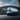 IONIQ 6 N drives under an arching bridge, showcasing its modern design against a cityscape.