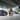 Zwei Männer stehen in einem Autohaus vor drei Hyundai Modellen und strecken den Daumen in die Höhe.