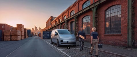 Електрическият Hyundai STARIA Cargo пред индустриален склад.
